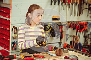 Young carpenter working in craft workshop. Creative student doing his project in workshop. Boy in the workshop makes crafts with