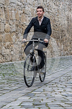 Young casual business man riding his bike