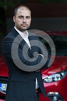 Young casual businessman with red car