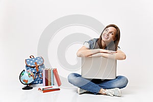 Young casual cheerful woman student lean on laptop pc computer looking up dreaming sitting near globe, backpack, school