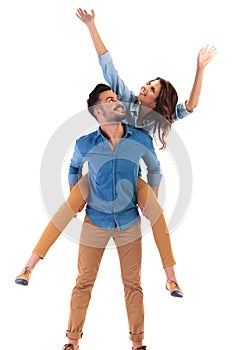 Young casual couple celebrating success and looking up