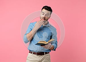 Young casual guy wetting fingers to flip pages photo