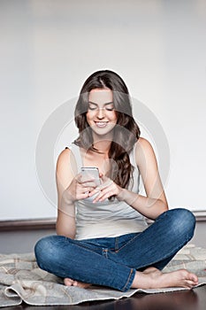 Young casual happy smiling girl with cell phone