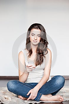 Young casual happy smiling girl with cell phone