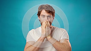 Young casual man covering his mouth in surprise, excited of something