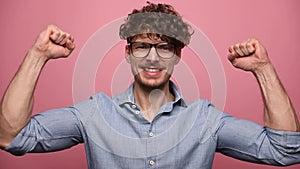 Young casual man with glasses on pink background