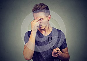 Young man with glasses suffering from eyestrain photo