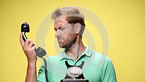 young casual man in green polo shirt on yellow background