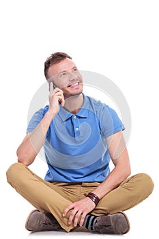 Young casual man on his phone looks away