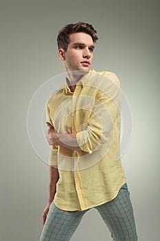 Young casual man holding his right arm