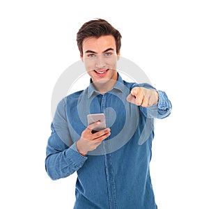 Young casual man holding phone and pointing finger