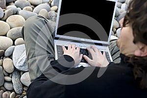 Young casual man with laptop computer in the beach