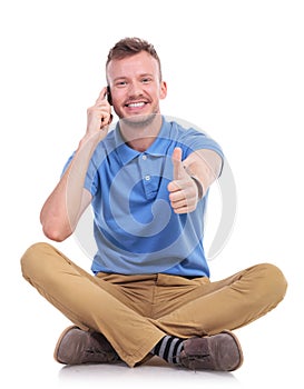 Young casual man on the phone shows thumb up