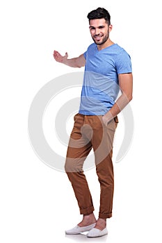 Young casual man presenting something