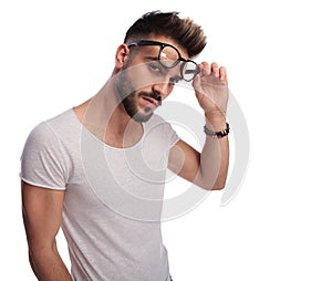 young casual man removes his glasses