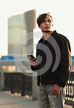 Young casual man in trouble standing on the street and chating o