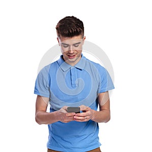 Young casual man txting on his phone