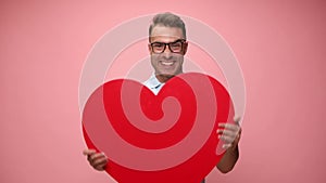 Young casual man wearing polo shirt on pink background