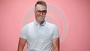 Young casual man wearing polo shirt on pink background