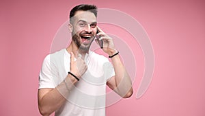 young casual man in white shirt posing on pink background