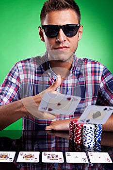 Young casual poker player throwing a pair of aces