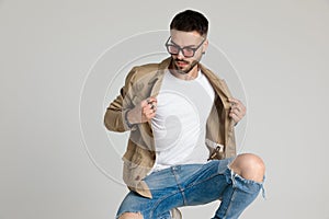 Young casual unshaved model adjusting jacket and posing