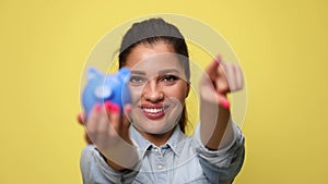 young casual woman in denim blue shirt on yellow background