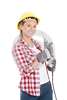Young casual woman holding drill and wearing safety helmet.