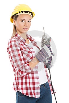 Young casual woman holding drill and wearing safety helmet.