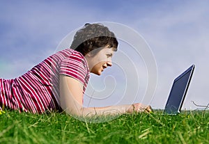 Young casual woman working on laptop