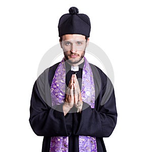 Young catholic priest praying