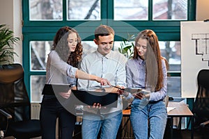 Young caucasian architects or designers using color palette for new project on the laptop in the stylish modern office