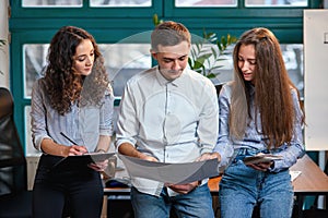 Young caucasian architects or designers using color palette for new project on the laptop in the stylish modern office