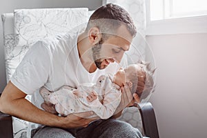 Young Caucasian bearded father dad holding newborn baby son daughter