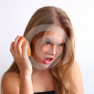 Young caucasian blonde girl with orange citrus fruit, healthy concept