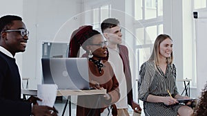 Young Caucasian boss smiles, shakes hands with African colleague at multiethnic office team meeting slow motion RED EPIC