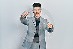 Young caucasian boy with ears dilation wearing business jacket approving doing positive gesture with hand, thumbs up smiling and