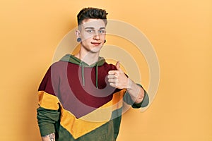 Young caucasian boy with ears dilation wearing casual sweatshirt doing happy thumbs up gesture with hand