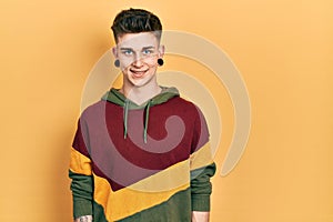 Young caucasian boy with ears dilation wearing casual sweatshirt with a happy and cool smile on face