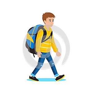 Young caucasian boy walking with a blue backpack, dressed in yellow jacket and jeans. Casual style student going to