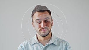 Young Caucasian Brunet Man is Looking at the Camera on a Light Gray Background. Studio Male Face Portrait. Natural Day