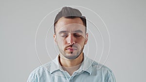 Young Caucasian Brunet Man is Looking at the Camera on a Light Gray Background. Studio Male Face Portrait. Natural Day