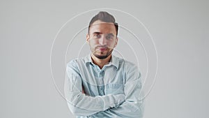 Young Caucasian Brunet Man is Looking at the Camera on a Light Gray Background. Studio Male Face Portrait. Natural Day