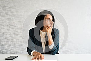 Young caucasian brunette business woman director in office look to side empty space being thoughtful make decisions in office