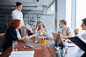 Young caucasian business team at a loss for solution sitting at a table