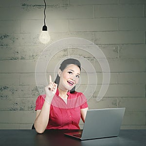 Young caucasian business woman having her aha moment with light bulb photo