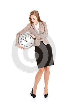 Young caucasian business woman holding clock.