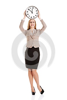 Young caucasian business woman holding clock.