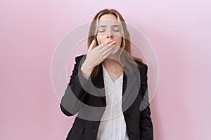 Young caucasian business woman wearing black jacket bored yawning tired covering mouth with hand