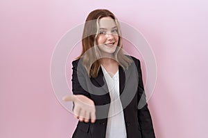 Young caucasian business woman wearing black jacket smiling cheerful offering palm hand giving assistance and acceptance